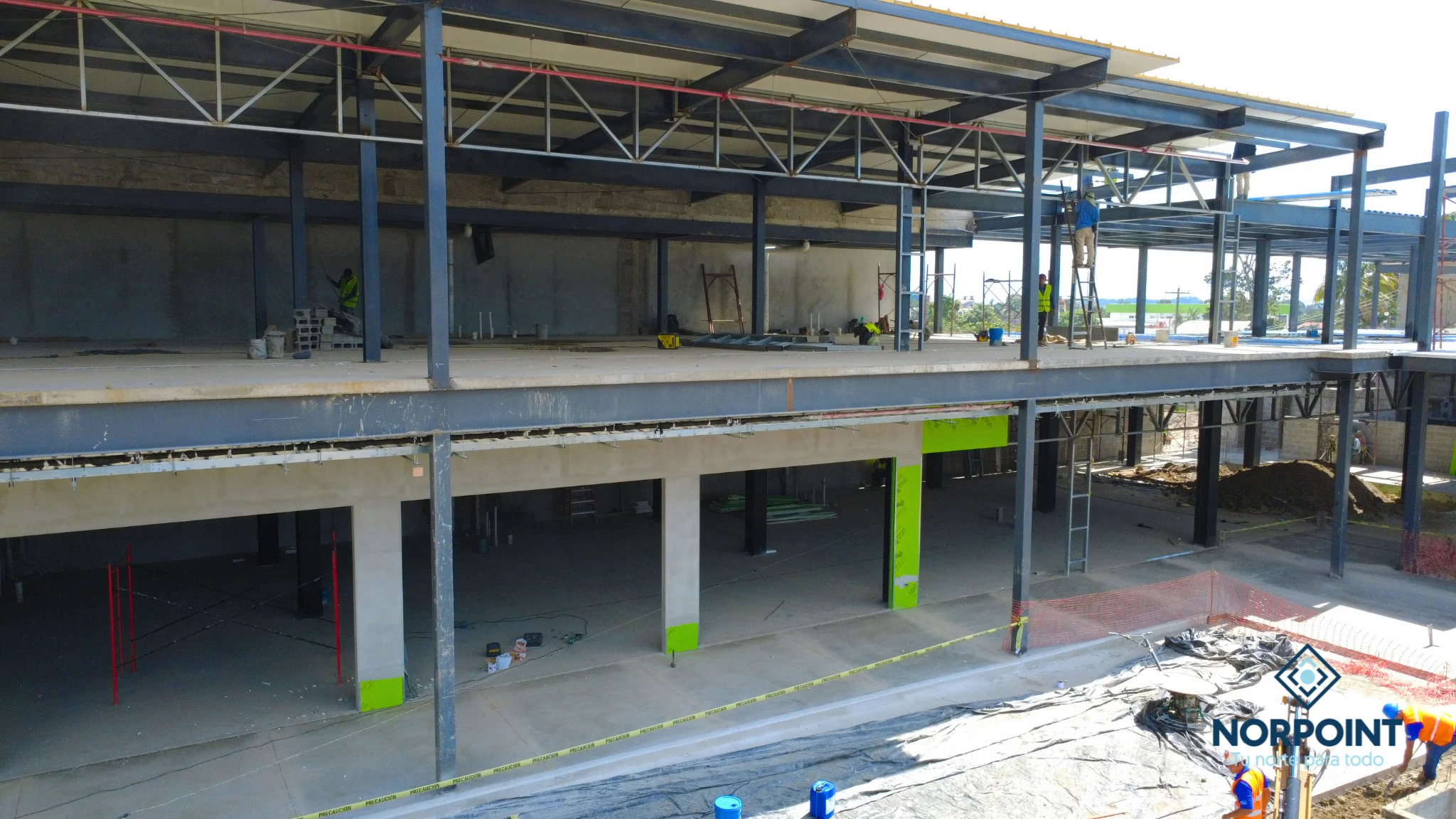 Interior del proyecto Norpoint en etapa estructural con niveles comerciales en desarrollo.