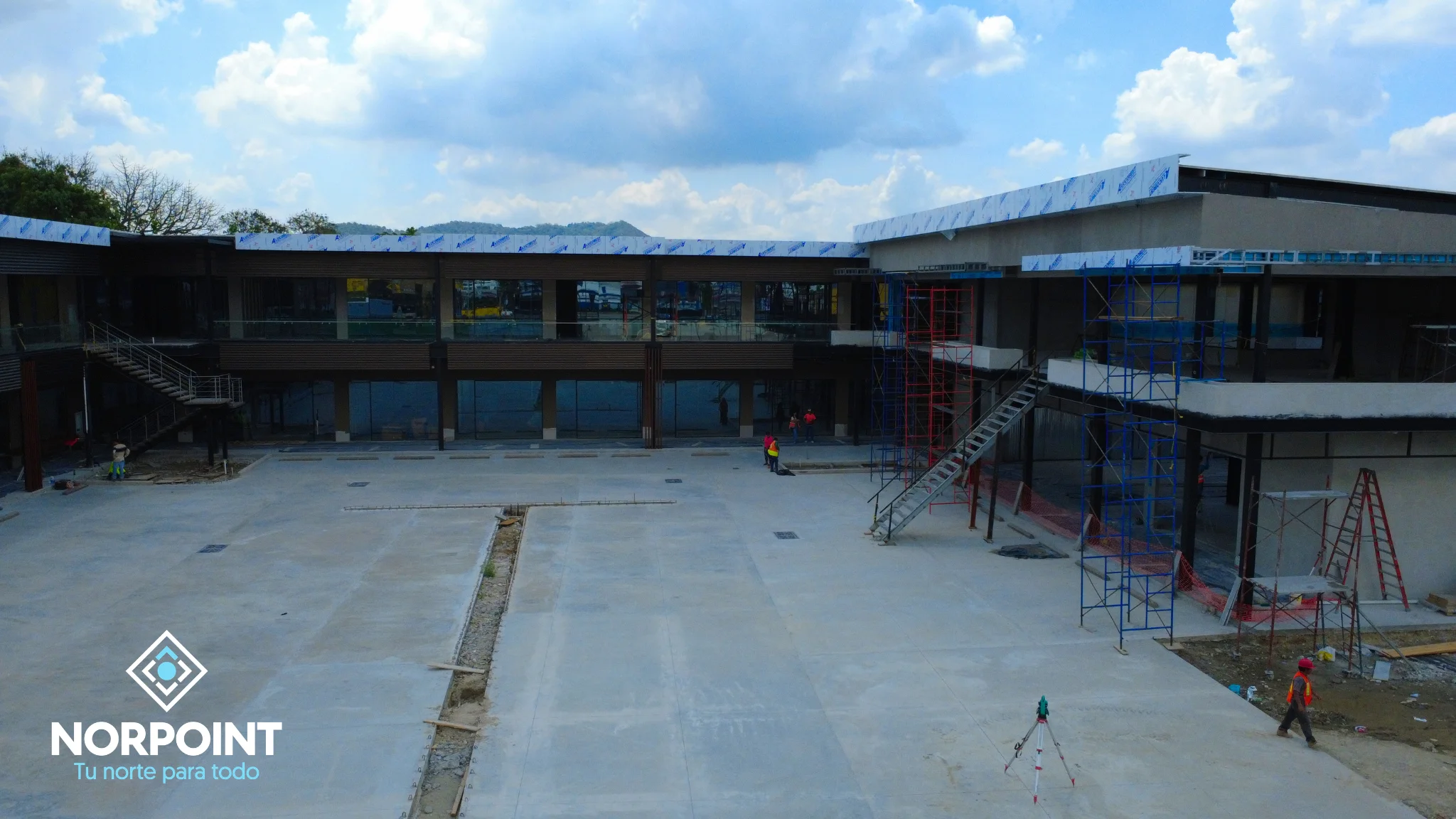 Avance de junio en Norpoint con vista interior de la plaza, estructura comercial definida y áreas exteriores en proceso de construcción.