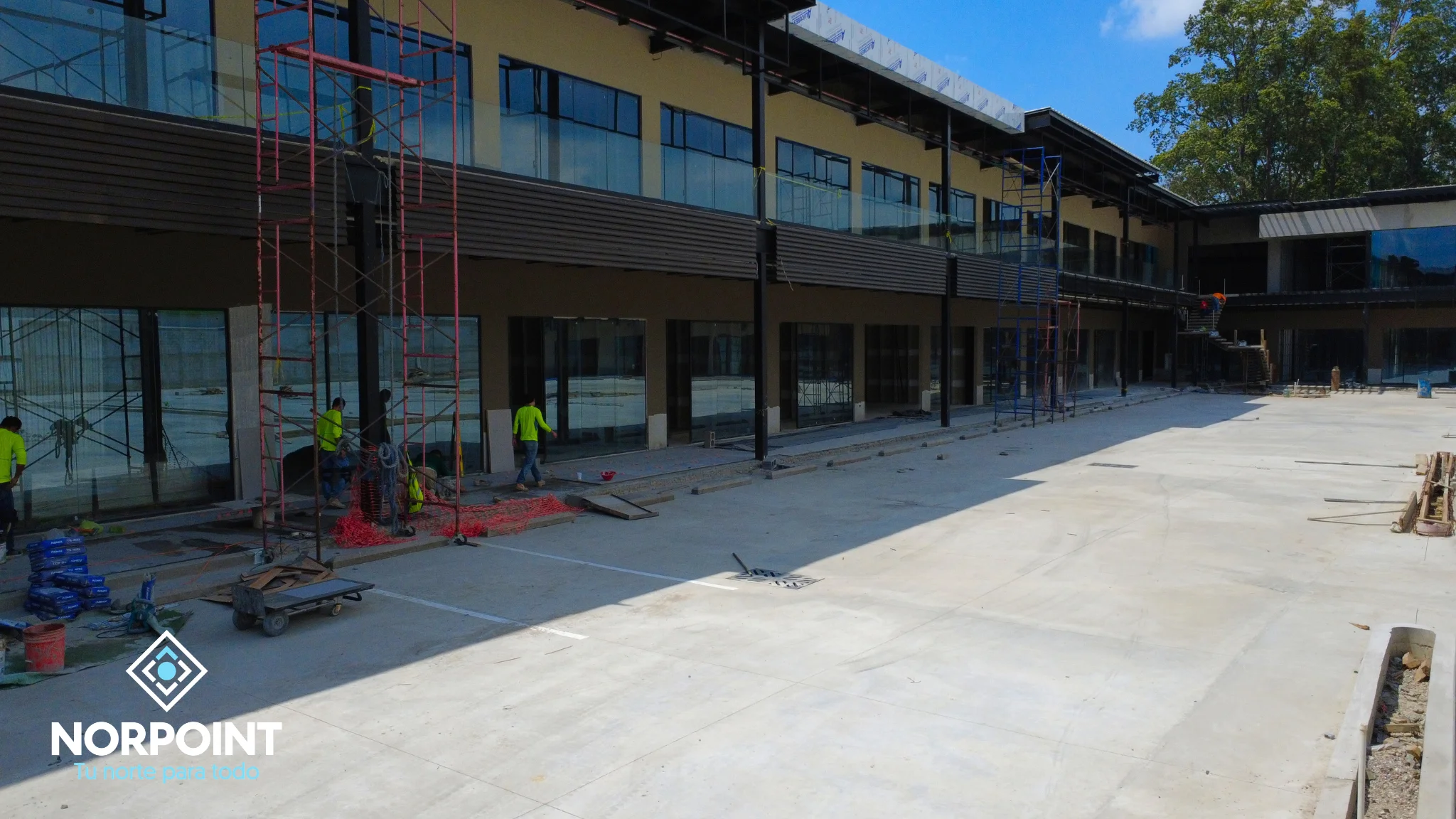 Avance de junio en Norpoint con fachada comercial en construcción, pasillos amplios y progreso visible en los módulos del proyecto.