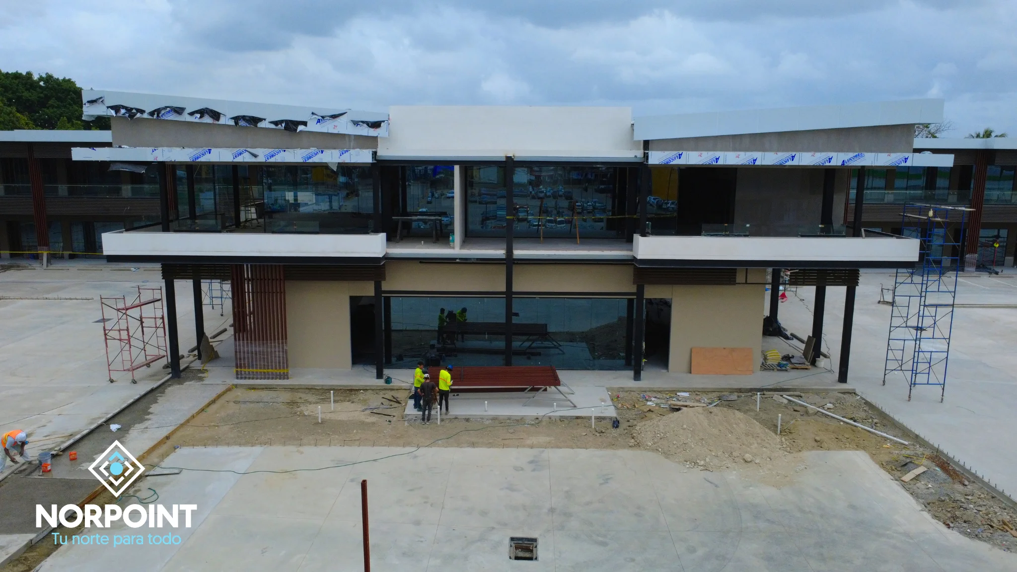 Avance de julio en Norpoint con frente comercial en desarrollo, acceso central definido y progreso visible en la construcción del proyecto.
