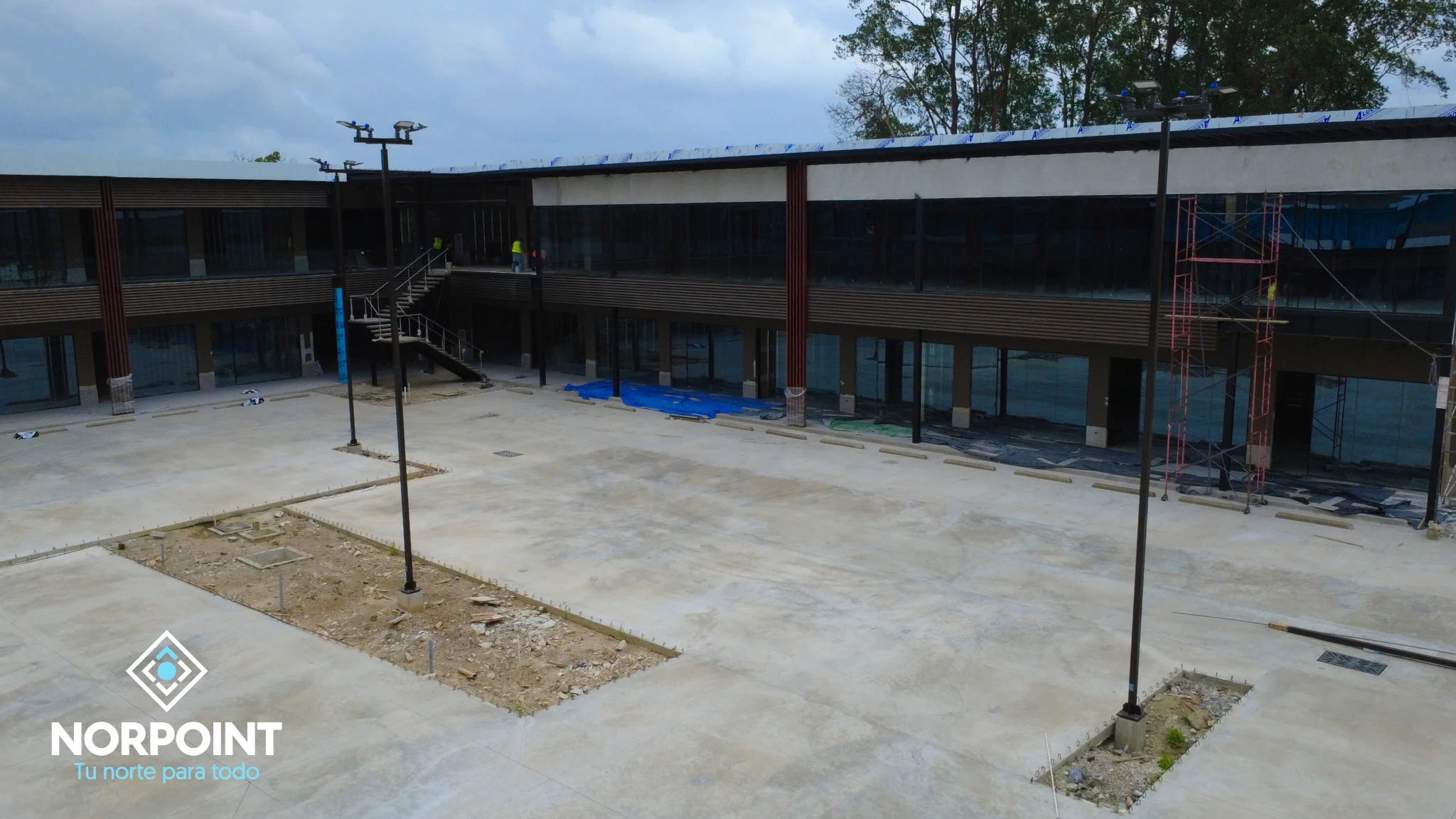 Avance de julio en Norpoint con corredor comercial en construcción, áreas peatonales en desarrollo y locales definidos.