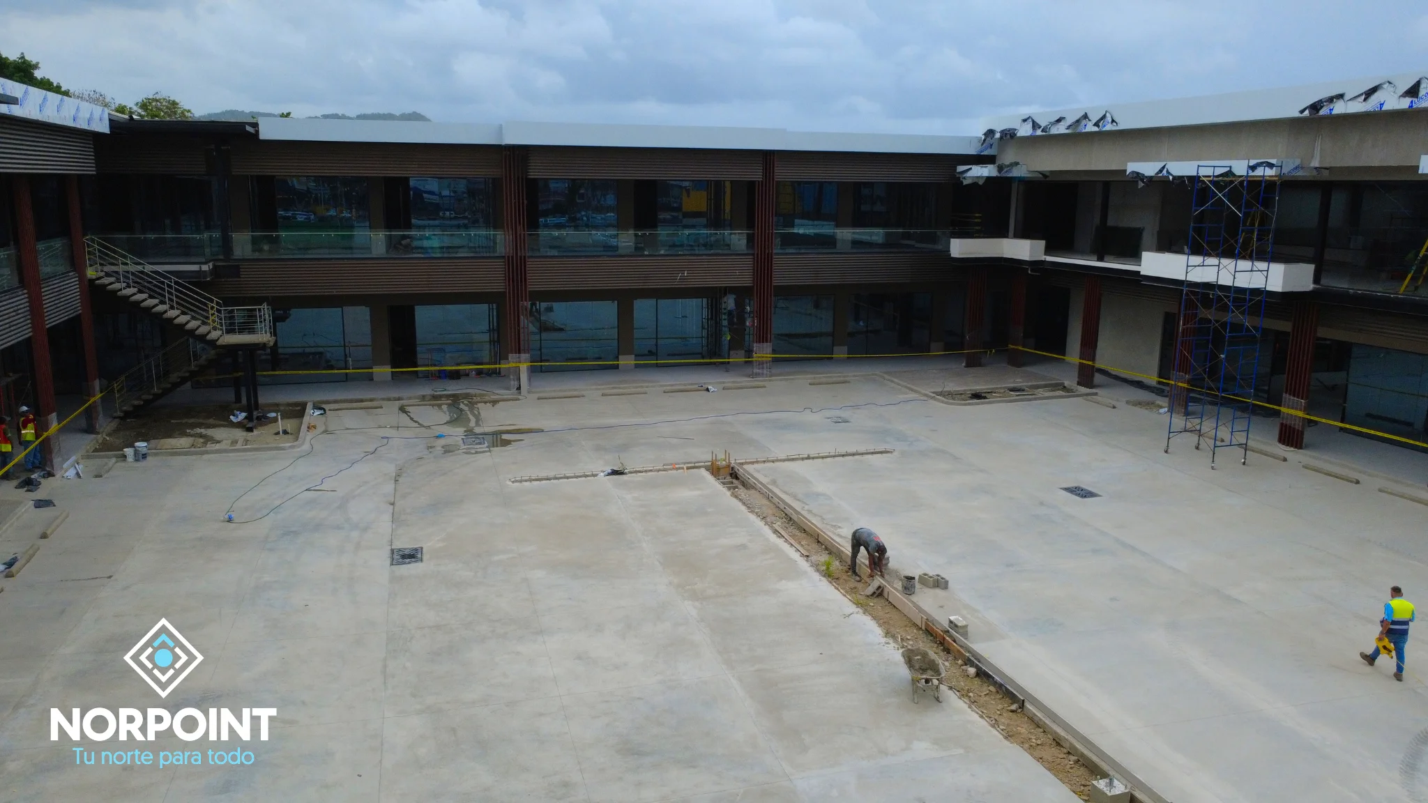 Avance de julio en Norpoint con área central en obra, estructura perimetral de locales y trabajos de construcción en desarrollo.