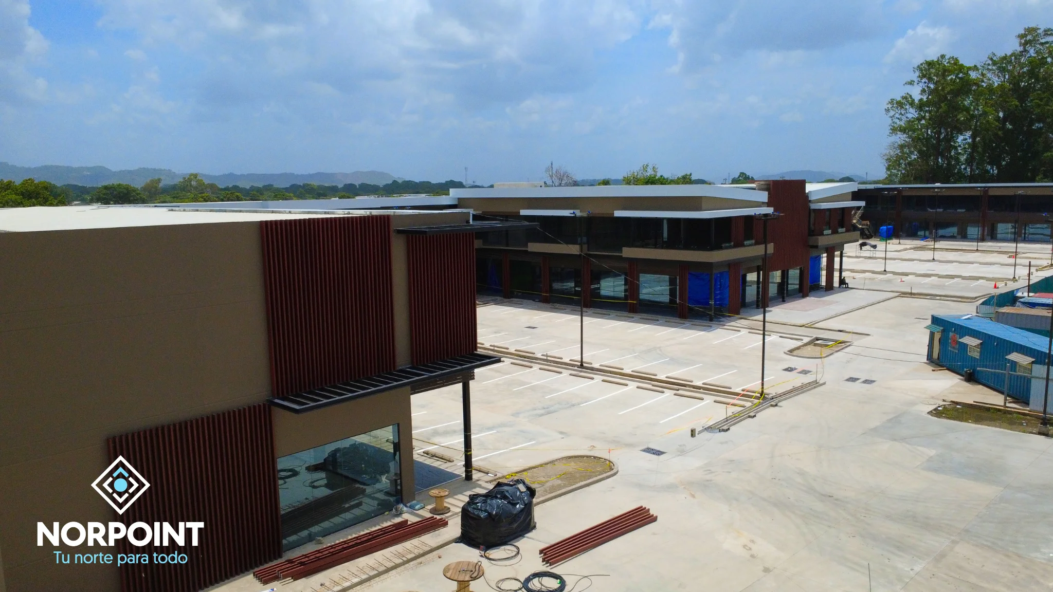Avance de agosto en Norpoint con áreas exteriores casi terminadas, fachada lateral en desarrollo y trabajos finales de construcción.