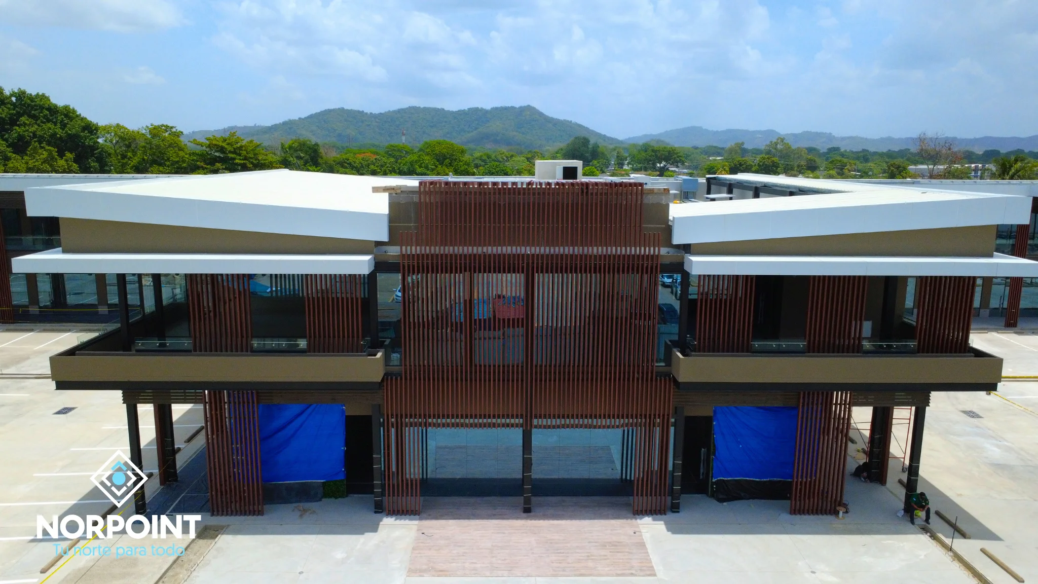 Avance de agosto en Norpoint con fachada principal más definida, acceso comercial visible y progreso en la imagen del proyecto.
