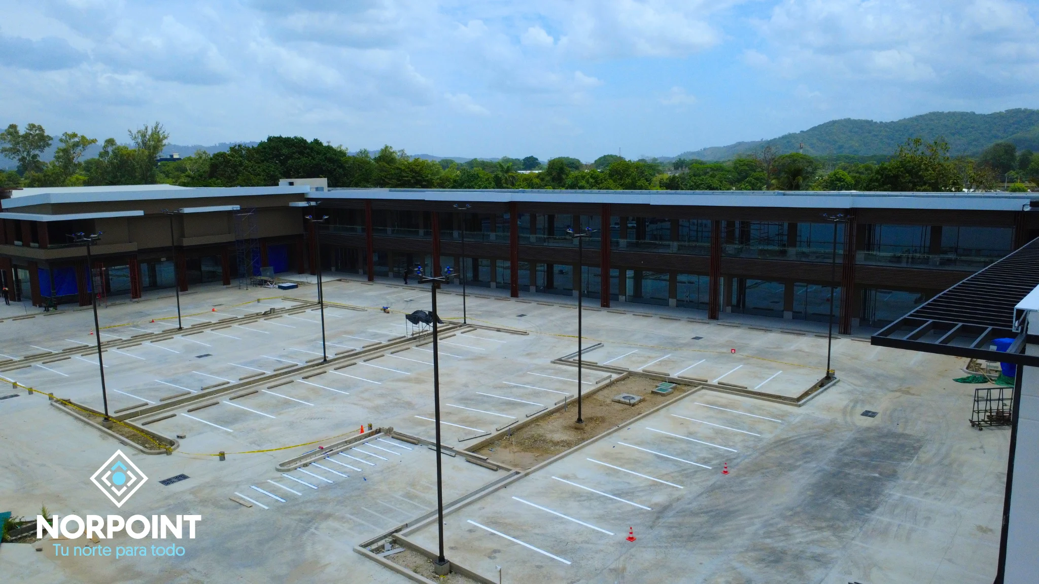 Avance de agosto en Norpoint con estacionamiento pavimentado, áreas de circulación amplias y módulos comerciales en etapa avanzada.