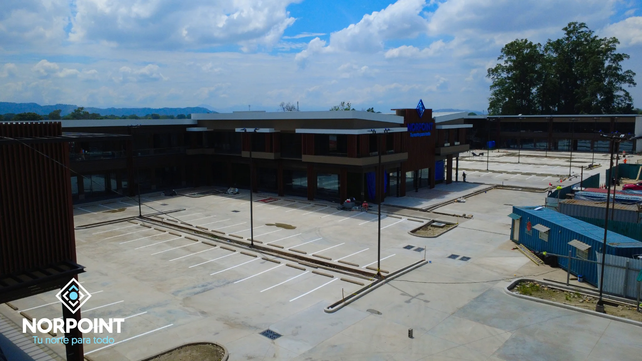 Vista amplia del área exterior y estacionamiento de Norpoint durante los trabajos finales de septiembre 2026.